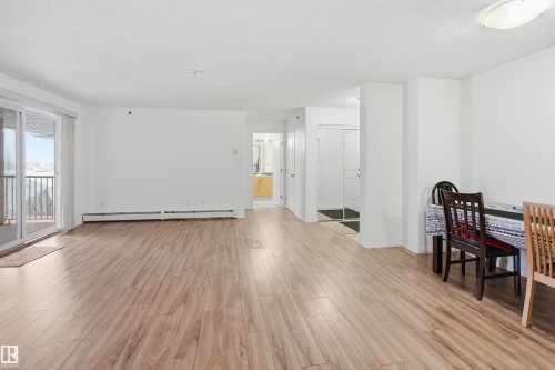 Dining area with light wood finished floors, a baseboard heating unit, and a textured ceiling - 407 2305 35A Avenue, Edmonton, AB - Indoor