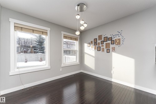 Unfurnished dining area with baseboards and dark wood finished floors - 6963 19A Avenue, Edmonton, AB - Indoor Photo Showing Other Room
