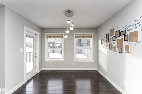 Unfurnished dining area featuring baseboards and dark wood-style flooring - 6963 19A Avenue, Edmonton, AB - Indoor Photo Showing Other Room