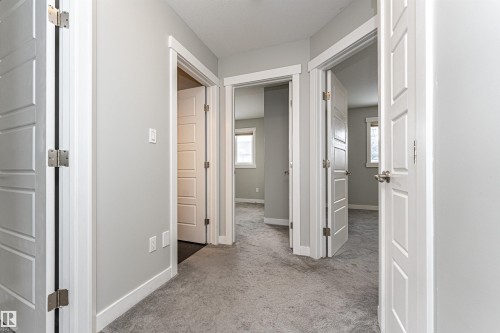 Hallway with light carpet and baseboards - 6963 19A Avenue, Edmonton, AB - Indoor Photo Showing Other Room