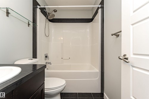 Full bathroom featuring vanity,  shower combination, and dark tile patterned flooring - 6963 19A Avenue, Edmonton, AB - Indoor Photo Showing Bathroom