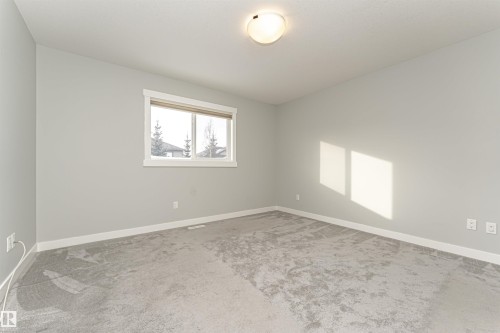 Unfurnished room featuring light carpet and baseboards - 6963 19A Avenue, Edmonton, AB - Indoor Photo Showing Other Room