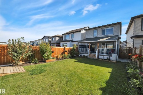 Back of house featuring a fenced backyard, a wooden deck, a residential view, and a gate - 157 Larch Crescent, Leduc, AB - Outdoor With Deck Patio Veranda