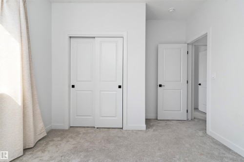 Unfurnished bedroom featuring light carpet and a closet - 5747 Kootook Way, Edmonton, AB - Indoor