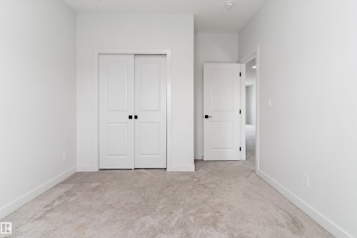 Unfurnished bedroom with light carpet and a closet - 5747 Kootook Way, Edmonton, AB - Indoor Photo Showing Other Room