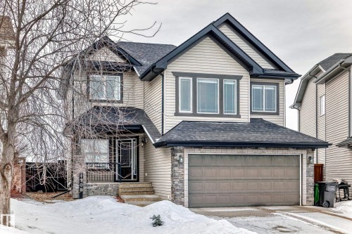 View of front facade with an attached garage, a shingled roof, and stone siding - 1908 69 Street, Edmonton, AB - Outdoor
