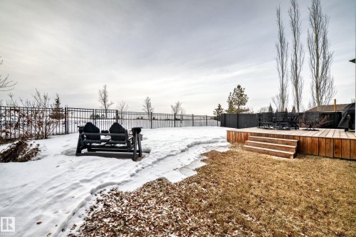 Yard covered in snow with a fenced backyard and a deck - 1908 69 Street, Edmonton, AB - Outdoor