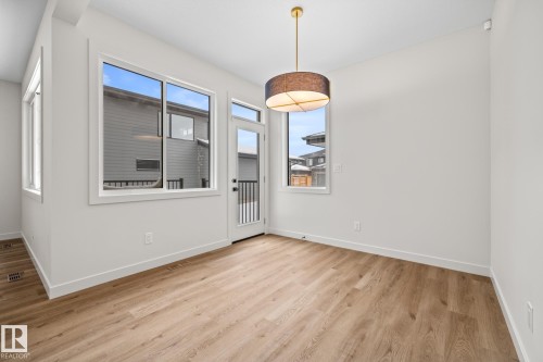 Unfurnished dining area featuring baseboards and light wood-style flooring - 4543 Knight Wynd, Edmonton, AB - Indoor Photo Showing Other Room