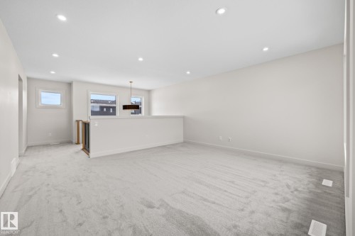 Unfurnished living room featuring light carpet and recessed lighting - 4543 Knight Wynd, Edmonton, AB - Indoor