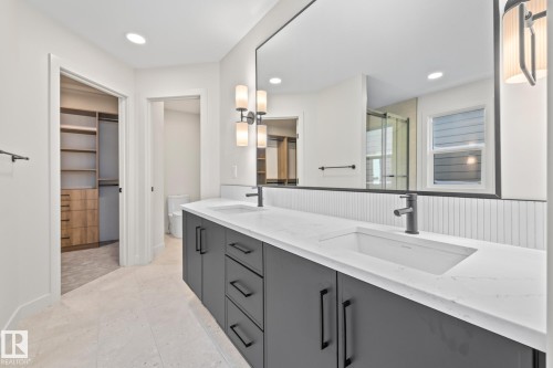 Full bath with a spacious closet, a shower stall, double vanity, a wainscoted wall, and recessed lighting - 4543 Knight Wynd, Edmonton, AB - Indoor
