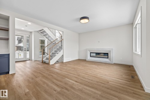 Unfurnished living room featuring light wood-style floors, a glass covered fireplace, and recessed lighting - 4543 Knight Wynd, Edmonton, AB - Indoor Photo Showing Living Room With Fireplace