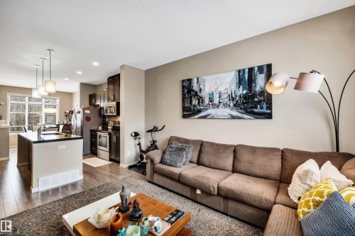 Living area featuring light wood-type flooring and recessed lighting - 8 320 Secord Boulevard, Edmonton, AB - Indoor Photo Showing Living Room
