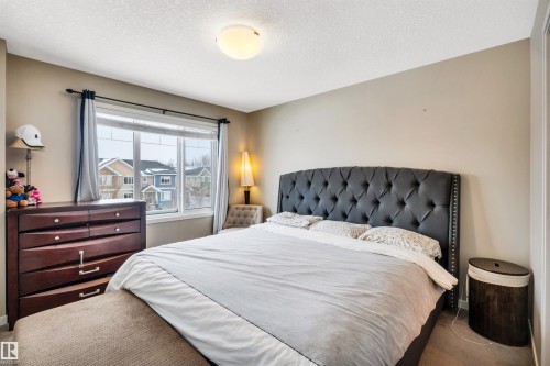 Carpeted bedroom with baseboards and a textured ceiling - 8 320 Secord Boulevard, Edmonton, AB - Indoor Photo Showing Bedroom