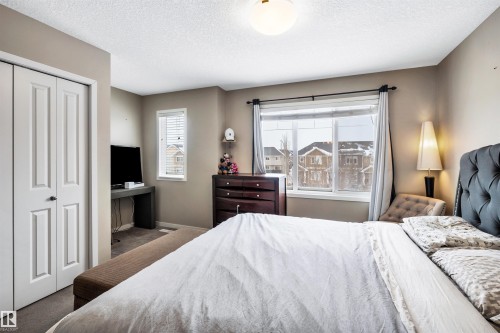 Bedroom featuring a closet, carpet, and a textured ceiling - 8 320 Secord Boulevard, Edmonton, AB - Indoor Photo Showing Bedroom