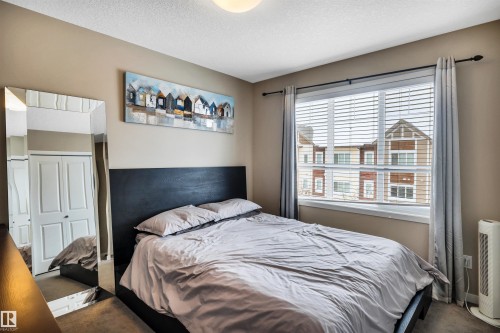 Bedroom with carpet flooring and a textured ceiling - 8 320 Secord Boulevard, Edmonton, AB - Indoor Photo Showing Bedroom