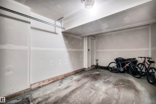 Garage featuring a garage door opener - 8 320 Secord Boulevard, Edmonton, AB - Indoor Photo Showing Garage