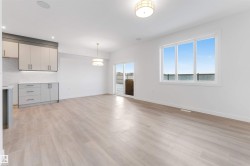 Unfurnished living room featuring baseboards and light wood-style floors - 