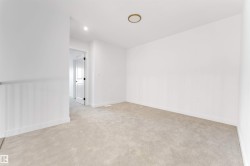 Empty room with light carpet and recessed lighting - 