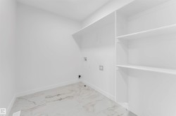 Laundry area featuring hookup for a washing machine and light marble finish floors - 