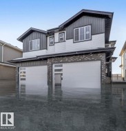 View of front of property with a garage and board and batten siding - 