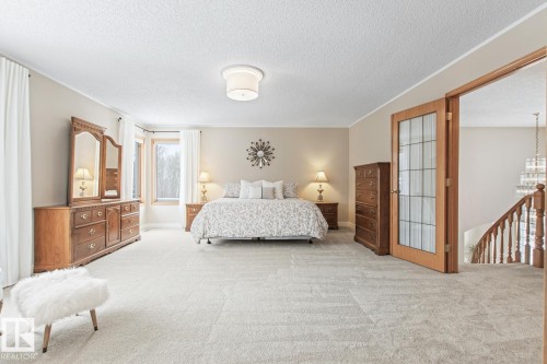Carpeted bedroom with a textured ceiling and suspended lighting - 121 Weaver Drive, Edmonton, AB - Indoor Photo Showing Bedroom