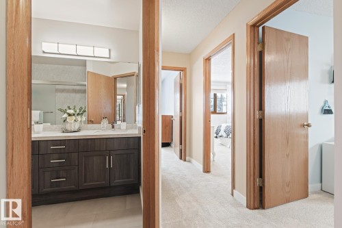 Bathroom featuring vanity, a textured ceiling, light carpet, and light tile patterned floors - 121 Weaver Drive, Edmonton, AB - Indoor