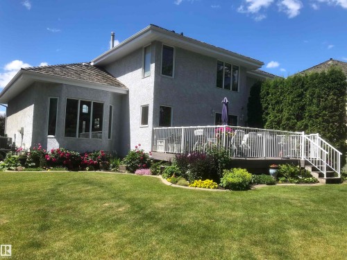 Back of property featuring stucco siding, a yard, and a deck - 121 Weaver Drive, Edmonton, AB - Outdoor