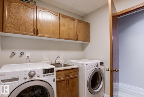 Laundry room featuring cabinet space and washing machine and clothes dryer - 121 Weaver Drive, Edmonton, AB - Indoor Photo Showing Laundry Room