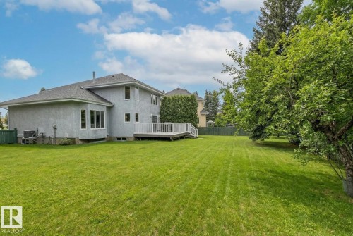 Rear view of property with a wooden deck, stucco siding, and a shingled roof - 121 Weaver Drive, Edmonton, AB - Outdoor With Deck Patio Veranda