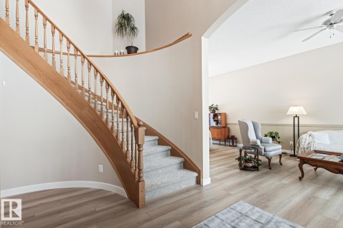 Stairs with wood finished floors, a ceiling fan, and a high ceiling - 121 Weaver Drive, Edmonton, AB - Indoor Photo Showing Other Room