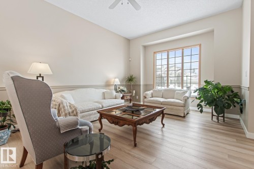 Living area featuring light wood-style flooring, a textured ceiling, and a ceiling fan - 121 Weaver Drive, Edmonton, AB - Indoor Photo Showing Living Room