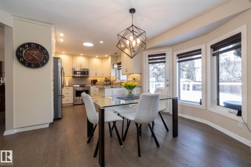Dining area featuring hanging lights, dark wood finished floors, and a textured ceiling - 932 110A Street, Edmonton, AB - Indoor Photo Showing Dining Room