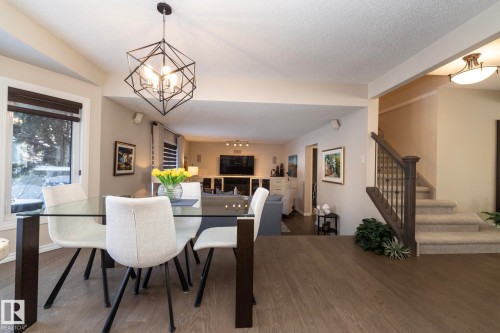 Dining room with wood finished floors, a textured ceiling, and hanging lights - 932 110A Street, Edmonton, AB - Indoor Photo Showing Dining Room