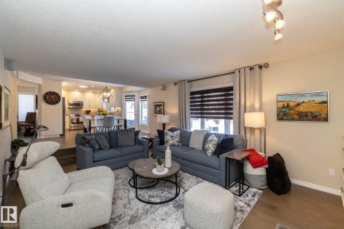 Living room with a chandelier, wood finished floors, and a textured ceiling - 932 110A Street, Edmonton, AB - Indoor Photo Showing Living Room