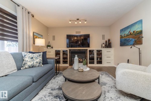 Living room with wood finished floors and a glass covered fireplace - 932 110A Street, Edmonton, AB - Indoor Photo Showing Living Room
