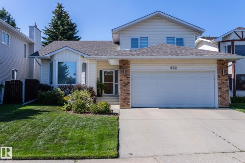 View of front facade featuring a shingled roof, an attached garage, driveway, a front yard, and brick siding - 932 110A Street, Edmonton, AB - Outdoor With Facade