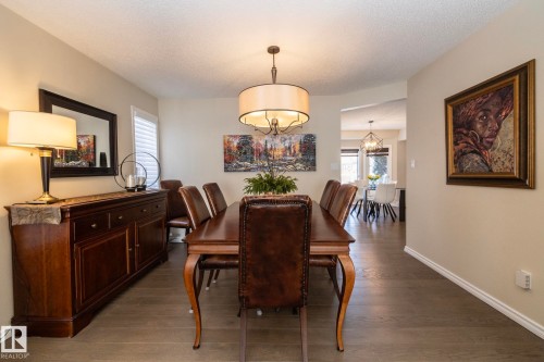 Dining area with dark wood finished floors, healthy amount of natural light, a chandelier, and a textured ceiling - 932 110A Street, Edmonton, AB - Indoor Photo Showing Dining Room