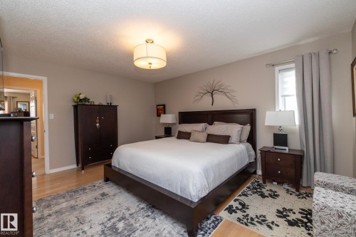 Bedroom with light wood-type flooring and a textured ceiling - 932 110A Street, Edmonton, AB - Indoor Photo Showing Bedroom