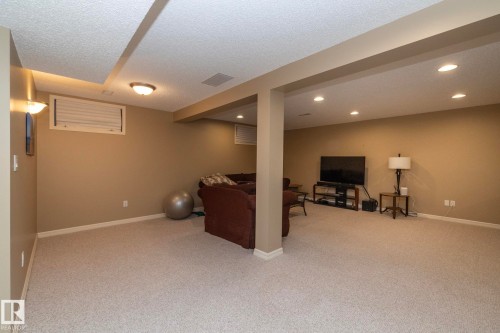 Carpeted living area featuring a textured ceiling and recessed lighting - 932 110A Street, Edmonton, AB - Indoor Photo Showing Other Room