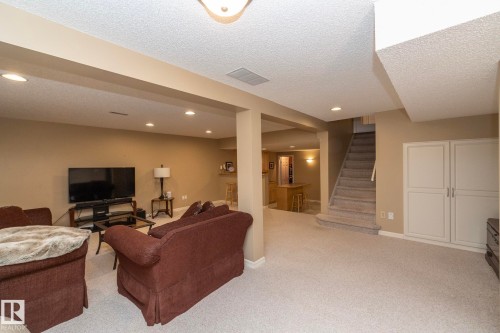 Living room featuring a textured ceiling, light carpet, and recessed lighting - 932 110A Street, Edmonton, AB - Indoor