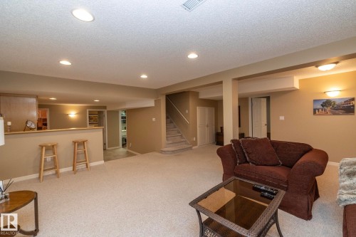 Living area with recessed lighting, a textured ceiling, light colored carpet, and bar area - 932 110A Street, Edmonton, AB - Indoor