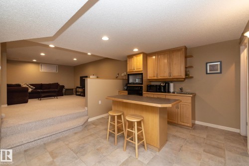 Kitchen featuring a kitchen bar, open floor plan, open shelves, black appliances, and recessed lighting - 932 110A Street, Edmonton, AB - Indoor Photo Showing Kitchen