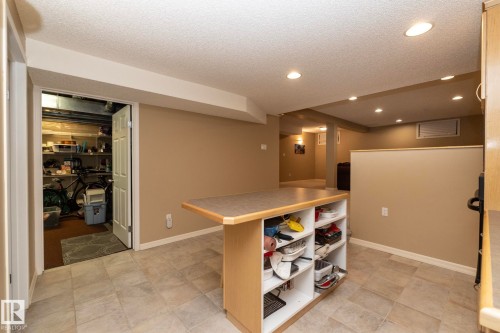 Kitchen with a textured ceiling, open shelves, recessed lighting, light countertops, and a center island - 932 110A Street, Edmonton, AB - Indoor Photo Showing Other Room