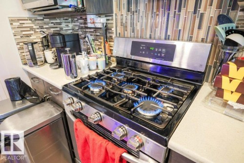 Kitchen view of stainless steel gas stove and backsplash - 1426 25 Avenue Nw, Edmonton, AB - Indoor