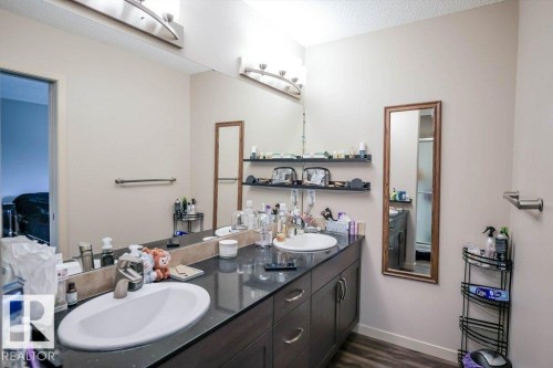 Full bath featuring double vanity and dark wood finished floors - 1426 25 Avenue Nw, Edmonton, AB - Indoor Photo Showing Bathroom