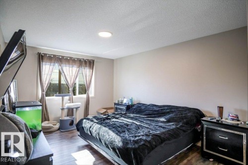 Bedroom featuring dark wood-type flooring and a textured ceiling - 1426 25 Avenue Nw, Edmonton, AB - Indoor Photo Showing Bedroom