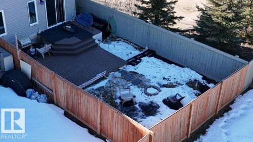 View of snowy exterior featuring a fenced backyard and a deck - 1426 25 Avenue Nw, Edmonton, AB - Outdoor With Exterior