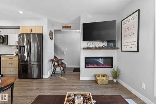 Living room with dark wood-type flooring, a glass covered fireplace, and recessed lighting - 9103 120 Avenue, Edmonton, AB - Indoor With Fireplace