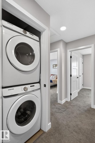 Laundry area featuring carpet, stacked washer / dryer, and recessed lighting - 9103 120 Avenue, Edmonton, AB - Indoor Photo Showing Laundry Room