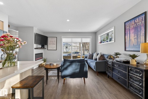 Living room featuring a glass covered fireplace, dark wood-style flooring, and recessed lighting - 9103 120 Avenue, Edmonton, AB - Indoor Photo Showing Living Room